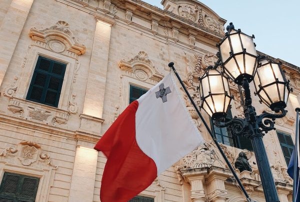 a flag hanging from a lamp post in front of a building